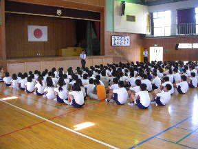 体育担当の先生の話を聞く子どもたち