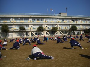 グラウンドいっぱいに響く元気な声で準備運動をする１年生(10:40)